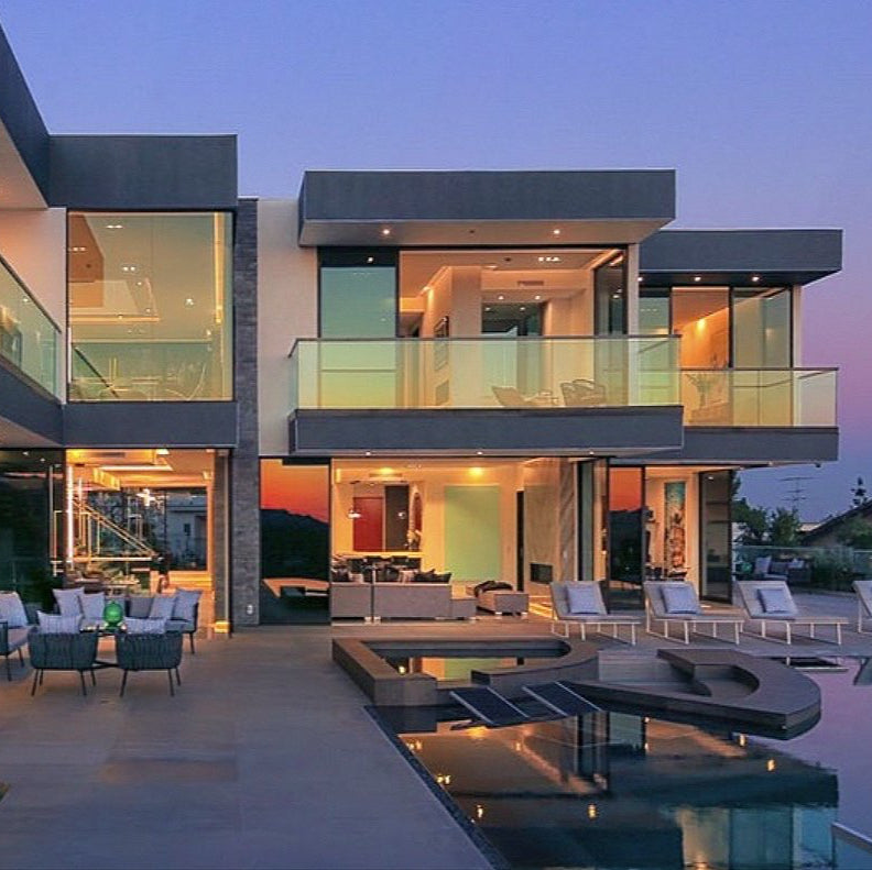 Modern house exterior with pool and outdoor furniture at dusk