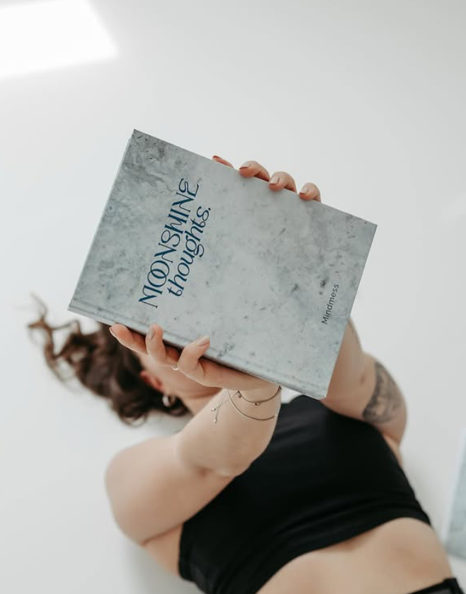 Elisabeth Wittauer holding her book titled 'Moonshine thoughts'. Image credit: Elisabeth Wittauer.