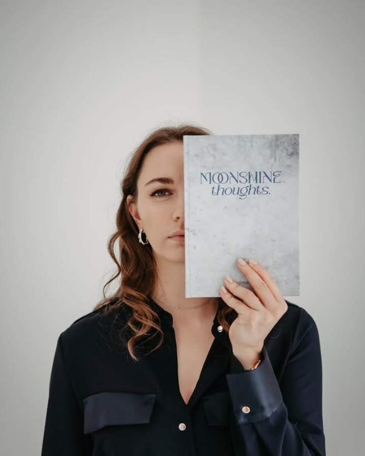Author Elisabeth Wittauer holding one of her books titled 'Moonshine thoughts'. Image credit: Elisabeth Wittauer.