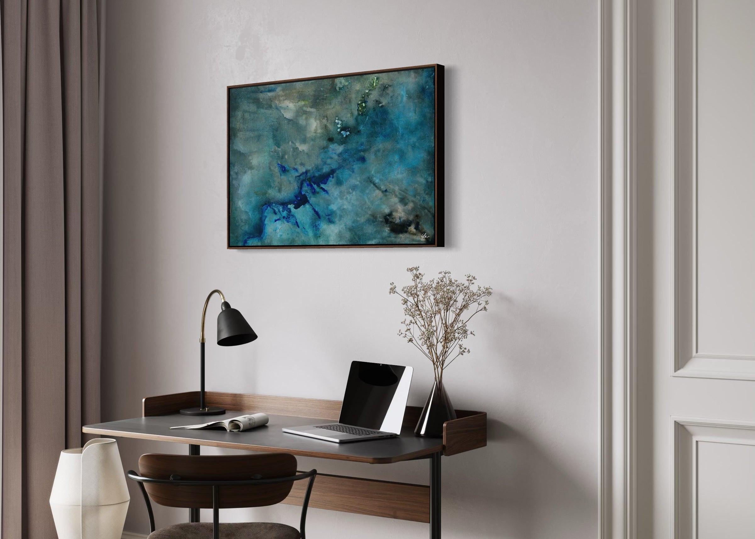 Abstract painting hanging above a little desk in a hotel room setting.