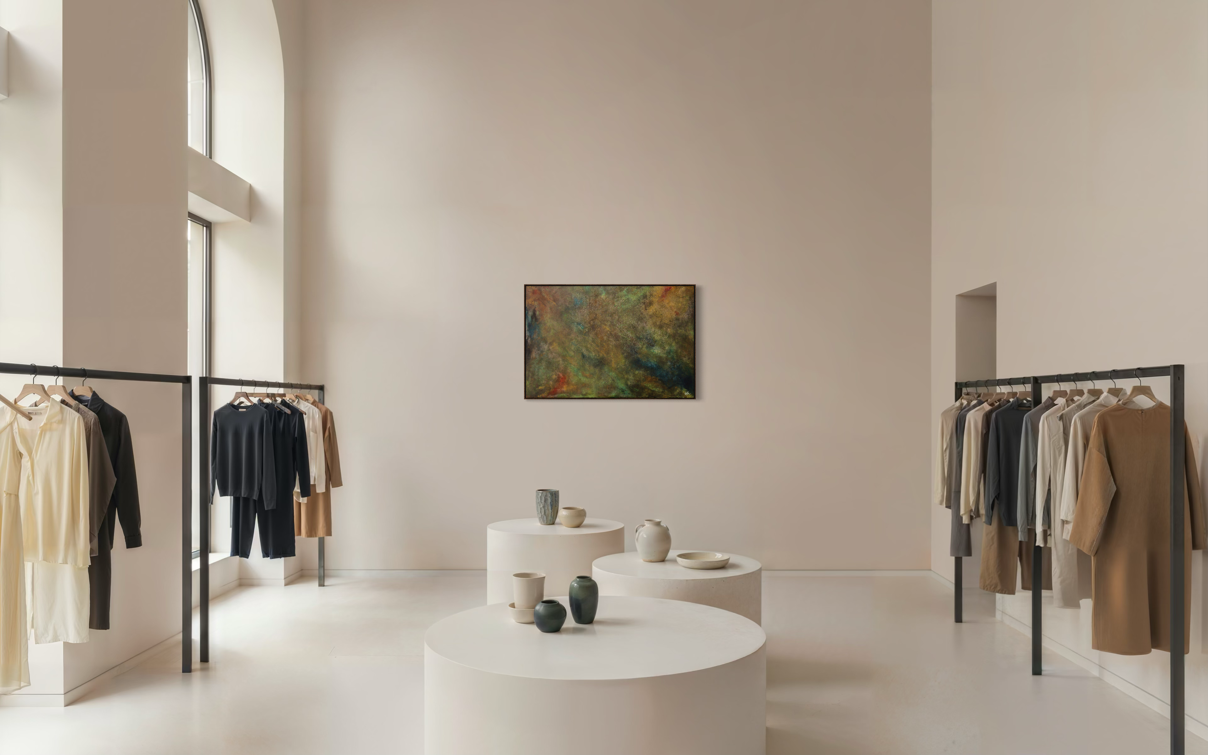 Modern interior with clothing racks and a painting on a wall.