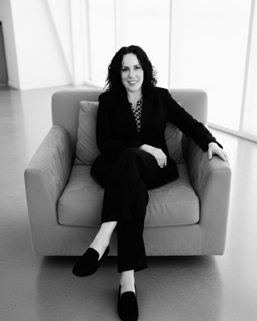 Elizabeth Ortiz sitting on a chair in a minimalistic room.
