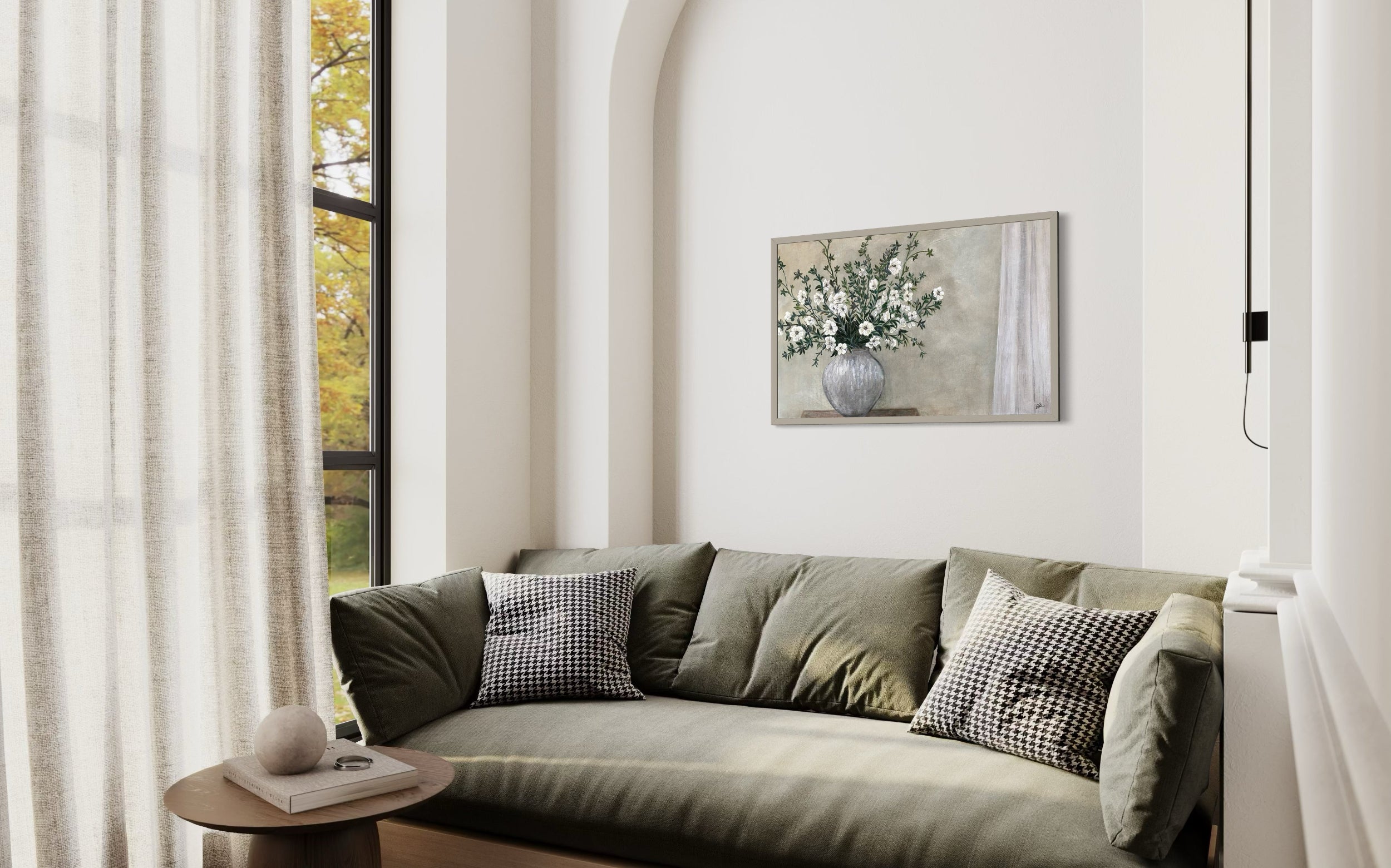 Modern room with a green sofa, decorative pillows, and a painting of flowers on the wall.