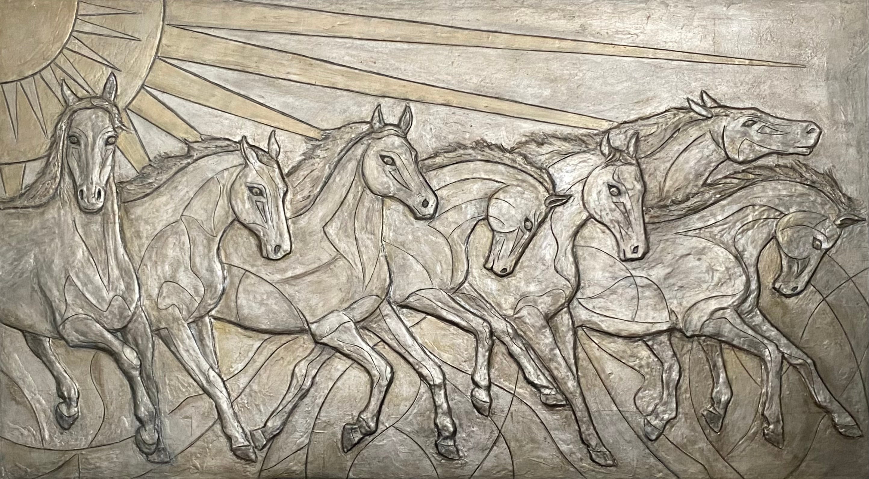 Relief sculpture of horses running with a sun-like circle above