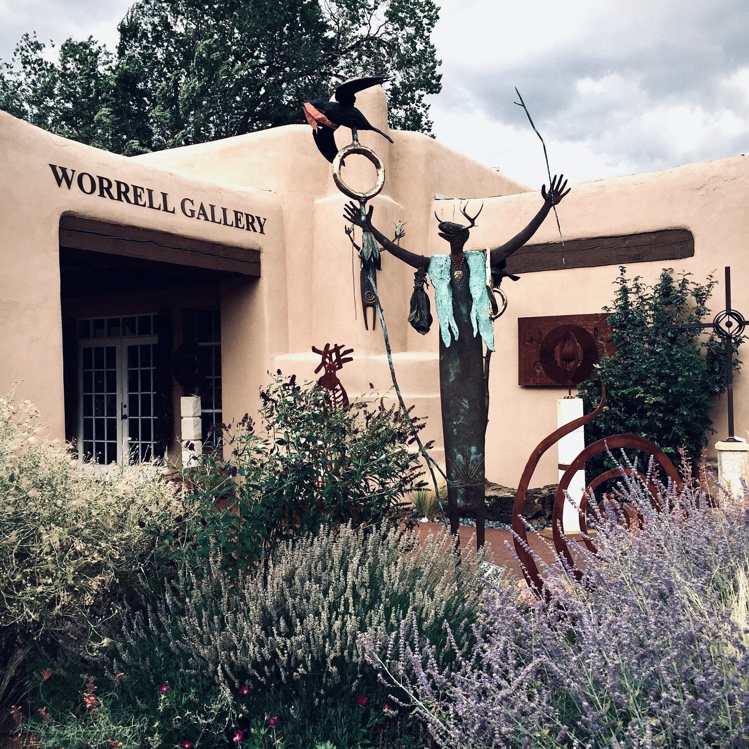 Image of a gallery in Santa Fe, New Mexico with a large sculpture in front of it.