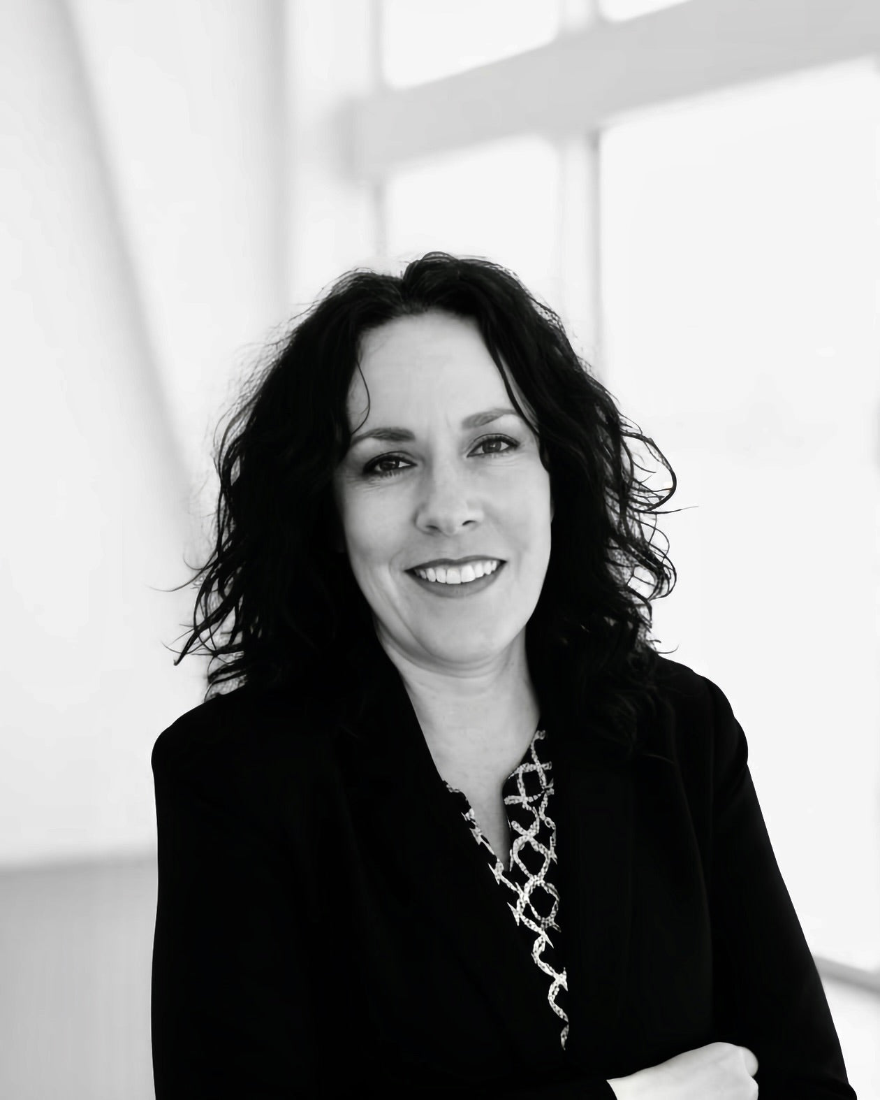 Black and white portrait of Elizabeth Ortiz with a blurred background.