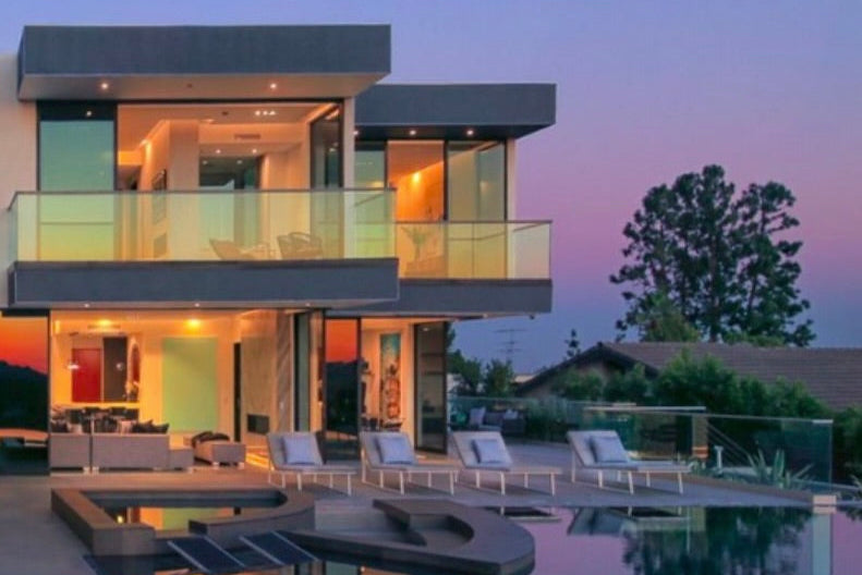 Modern house with a pool and outdoor seating area at dusk